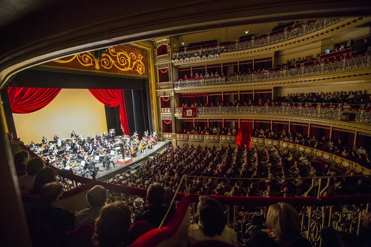 Oviedo Filarmonía actuando sobre el escenario del Teatro Campoamor ante un auditorio lleno.